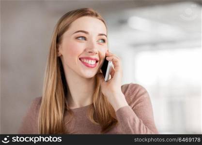business people, technology and corporate concept - happy smiling businesswoman calling on smartphone at office. businesswoman calling on smartphone at office