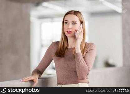 business people, technology and corporate concept - happy smiling businesswoman calling on smartphone at office. businesswoman calling on smartphone at office. businesswoman calling on smartphone at office
