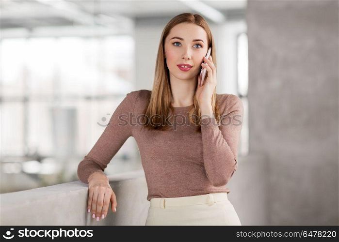 business people, technology and corporate concept - happy smiling businesswoman calling on smartphone at office. businesswoman calling on smartphone at office. businesswoman calling on smartphone at office