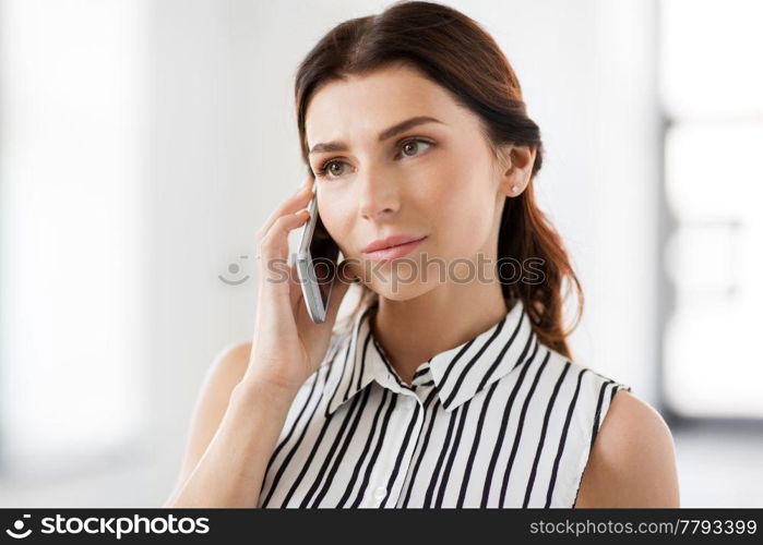 business people, technology and corporate concept - happy smiling businesswoman calling on smartphone at office. businesswoman calling on smartphone at office