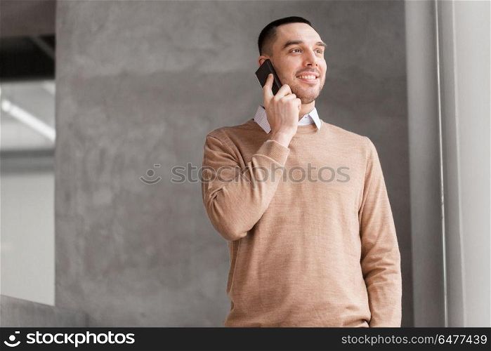 business people, technology and corporate concept - smiling businessman calling on smartphone at office. businessman calling on smartphone at office. businessman calling on smartphone at office