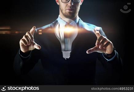 business, people, technology and cyberspace concept - close up of businessman in suit working with lightbulb projection over black background. close up of businessman with lightbulb projection