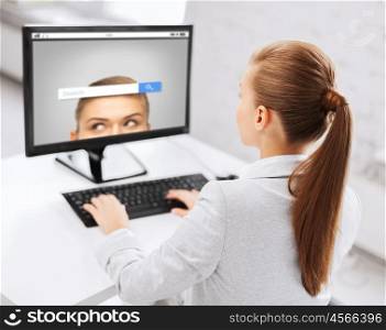 business, people, technology and education concept - businesswoman or student girl with internet browser search bar on computer screen sitting at office table
