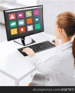 business, people, technology and education concept - businesswoman or student girl with menu icons on computer screen sitting at office table