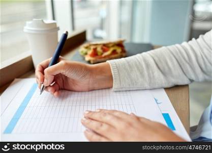 business, people, technology and lifestyle concept - woman with smartphone and paper form having lunch at cafe