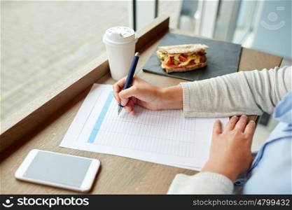 business, people, technology and lifestyle concept - woman with smartphone and paper form having lunch at cafe