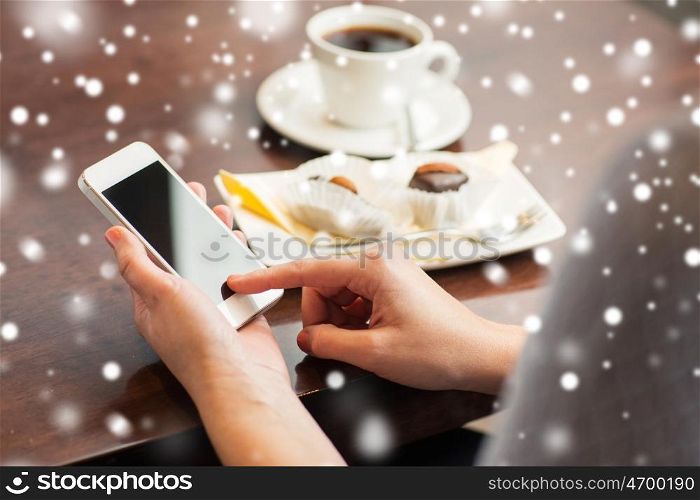 business, people, technology and lifestyle concept - woman with smartphone, coffee and dessert over snow