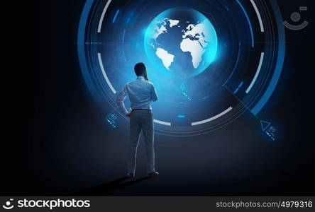 business, people, technology and mass media concept - businessman looking at virtual earth projection over dark background from back. businessman looking at virtual earth projection