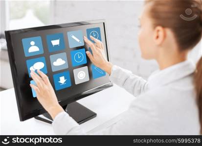 business, people, technology and media concept - woman with application icons on computer touchscreen in office