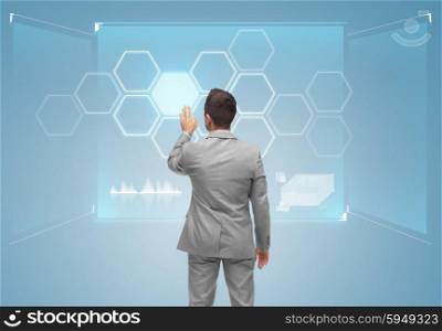business, people, technology and networking concept - businessman touching virtual screen with network from back over blue background