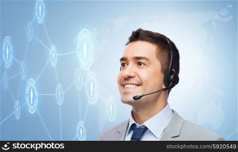 business, people, technology and service concept - smiling businessman in headset looking to virtual contacts icons projection over blue background