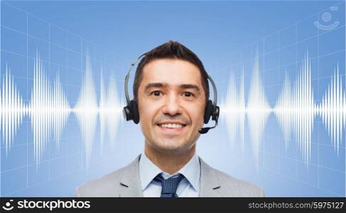 business, people, technology and service concept - smiling businessman in headset over sound wave or signal diagram on blue background