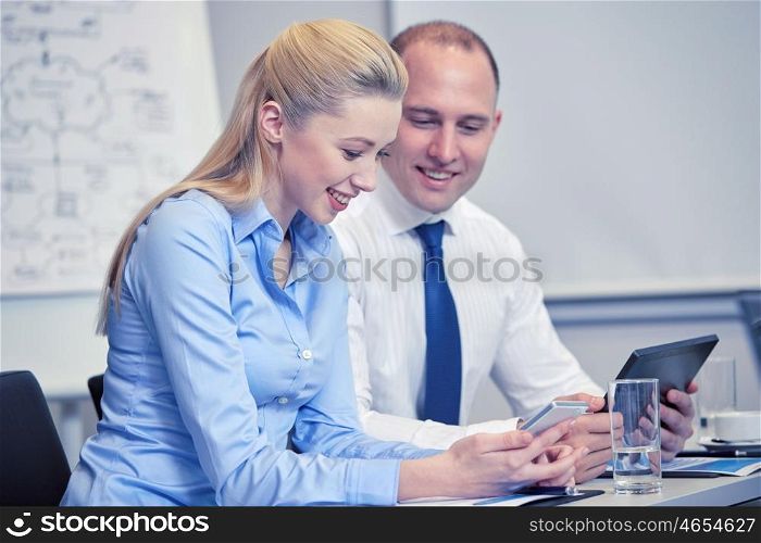business, people, technology and teamwork concept - smiling businesspeople with smartphone and tablet pc computer meeting in office
