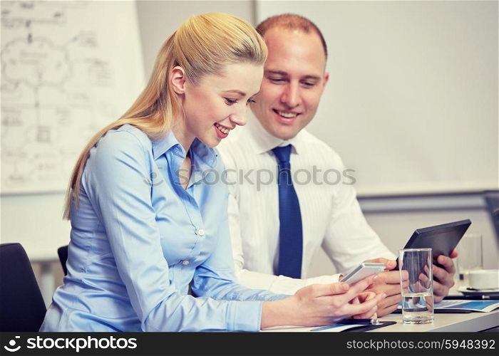 business, people, technology and teamwork concept - smiling businesspeople with smartphone and tablet pc computer meeting in office