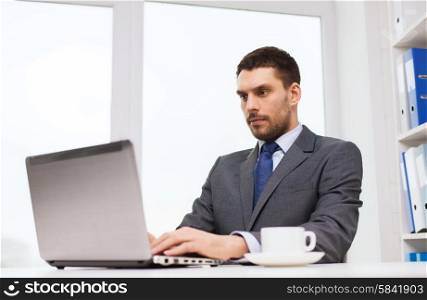 business, people, technology and work concept - businessman sitting in front of laptop and typing in office
