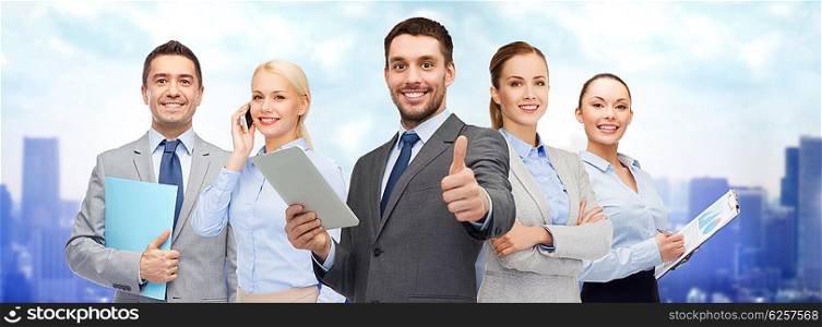 business, people, technology, gesture and office concept - group of smiling businessmen with tablet pc computer showing thumbs up over city background
