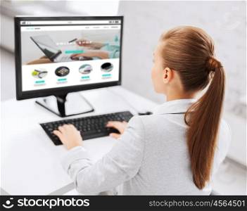 business, people, technology, internet shopping and education concept - businesswoman or student girl with online shop on computer screen sitting at office table. businesswoman with online shop on office computer