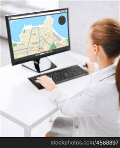 business, people, technology, navigation and education concept - businesswoman or student girl with gps navigator map on screen on computer screen sitting at office table