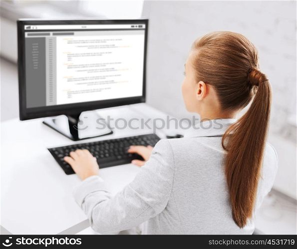 business, people, technology, programming and education concept - businesswoman or student girl with coding on computer screen sitting at office table