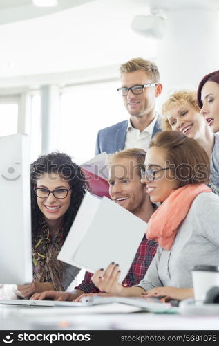 Business people using computer in creative office