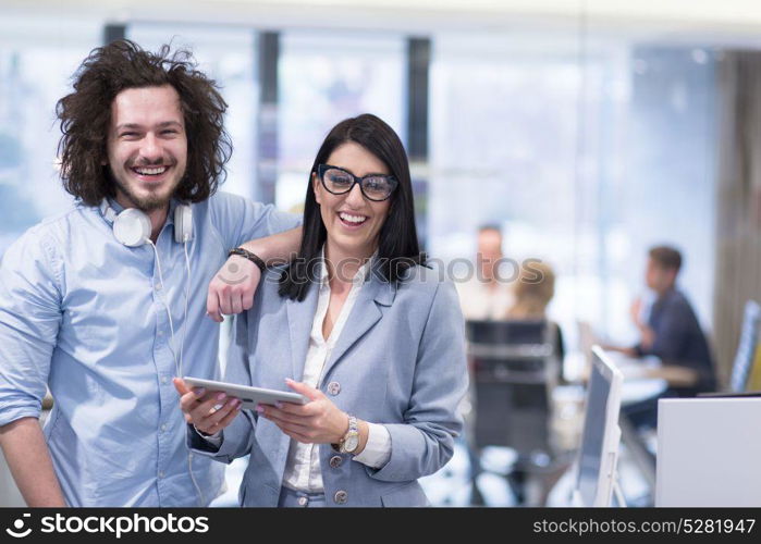 business people using tablet computer while preparing for next meeting colleagues in the background discussing ideas at startup office