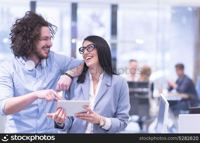 business people using tablet computer while preparing for next meeting colleagues in the background discussing ideas at startup office