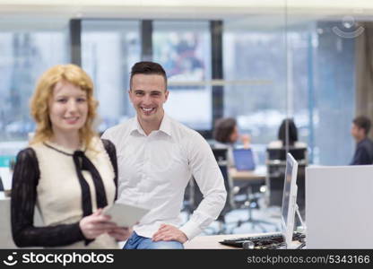 business people using tablet computer while preparing for next meeting colleagues in the background discussing ideas at startup office