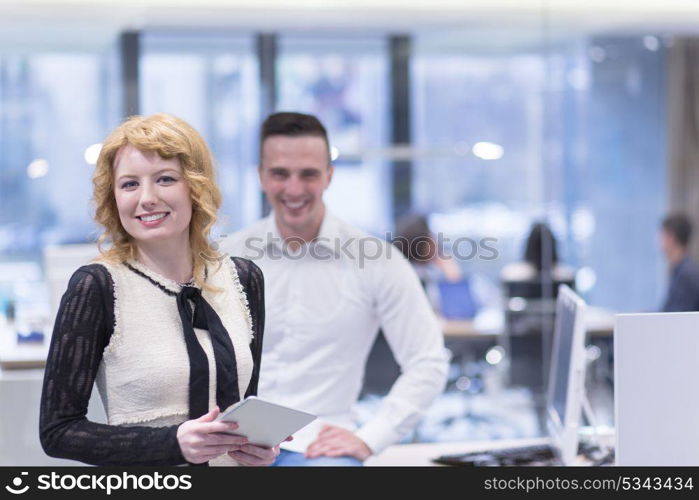 business people using tablet computer while preparing for next meeting colleagues in the background discussing ideas at startup office