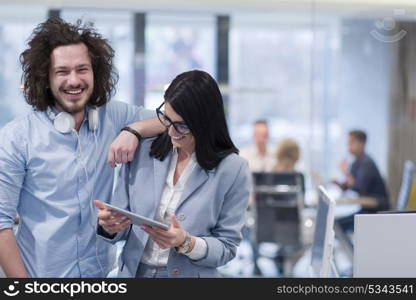 business people using tablet computer while preparing for next meeting colleagues in the background discussing ideas at startup office