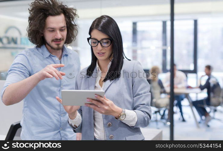 business people using tablet computer while preparing for next meeting colleagues in the background discussing ideas at startup office