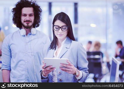 business people using tablet computer while preparing for next meeting colleagues in the background discussing ideas at startup office