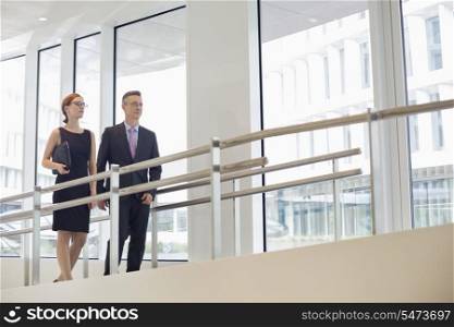 Business people walking by railing in office
