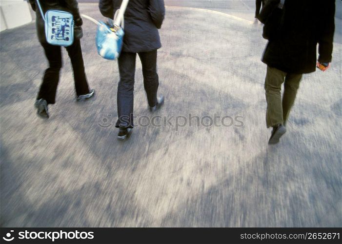 Business people walking, low section, rear view