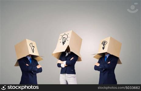 Business people wearing boxes. Unrecognizable business people wearing carton boxes on head