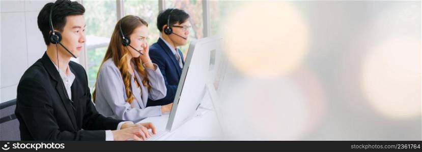 Business people wearing headset working in office in widen view to support remote customer or colleague. Call center, telemarketing, customer support agent provide service on telephone video call.. Business people wearing headset working in office in widen view
