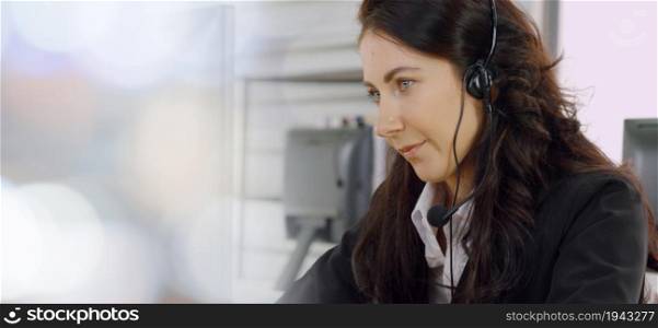 Business people wearing headset working in office to support remote customer or colleague. Call center, telemarketing, customer support agent provide service in broaden view .. Business people wearing headset working in office broaden view