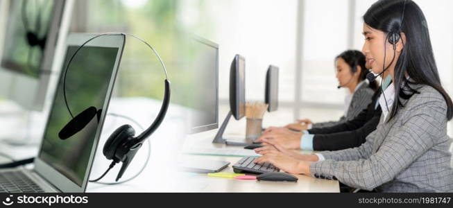 Business people wearing headset working in office to support remote customer or colleague. Call center, telemarketing, customer support agent provide service in broaden view .. Business people wearing headset working in office broaden view