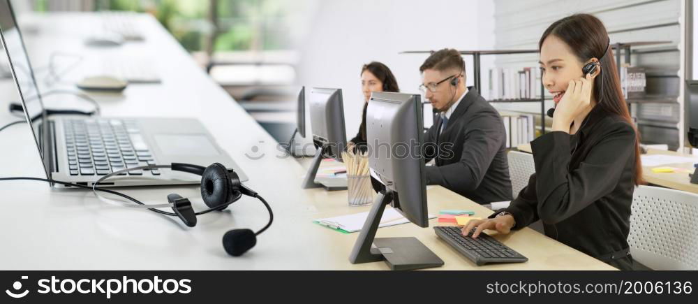 Business people wearing headset working in office to support remote customer or colleague. Call center, telemarketing, customer support agent provide service in broaden view .. Business people wearing headset working in office broaden view