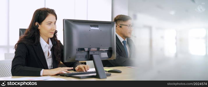 Business people wearing headset working in office to support remote customer or colleague. Call center, telemarketing, customer support agent provide service in broaden view .. Business people wearing headset working in office broaden view