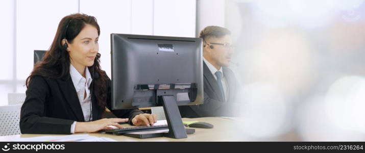 Business people wearing headset working in office to support remote customer or colleague. Call center, telemarketing, customer support agent provide service in broaden view .. Business people wearing headset working in office broaden view