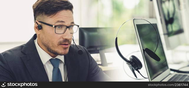 Business people wearing headset working in office to support remote customer or colleague. Call center, telemarketing, customer support agent provide service in broaden view .. Business people wearing headset working in office broaden view