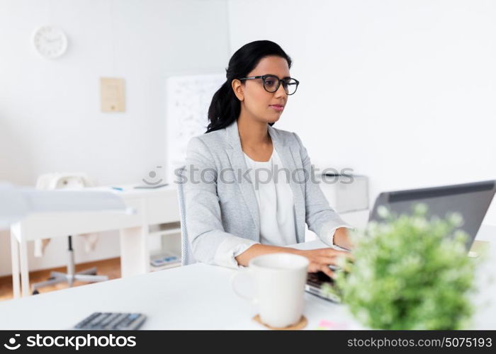 business, people, work and technology concept - happy businesswoman with laptop computer at office. happy businesswoman with laptop at office