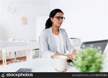business, people, work and technology concept - happy businesswoman with laptop computer at office. happy businesswoman with laptop at office