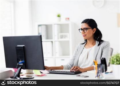 business, people, work and technology concept - happy smiling businesswoman with computer at office. happy businesswoman with computer at office