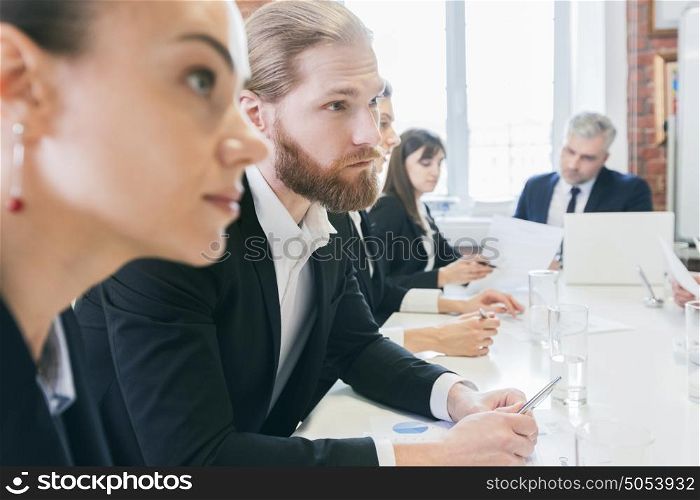 Business people work with documents. Business people sitting at the table in a row and work with documents