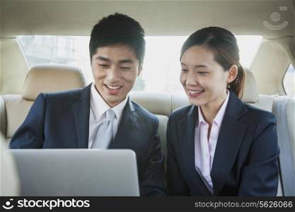 Business People Working in Back Seat of Car