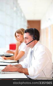 Business people working in front of computer with headphones