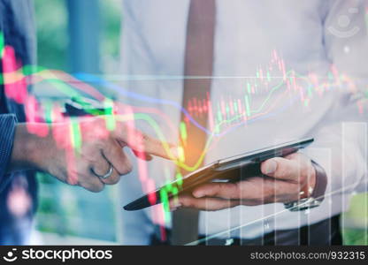 Business people working on digital tablet Stock market exchange information and Trading graph
