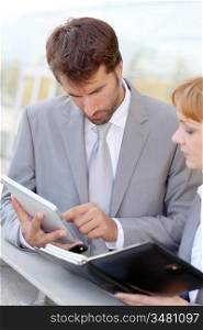 Business people working outside on electronic tablet