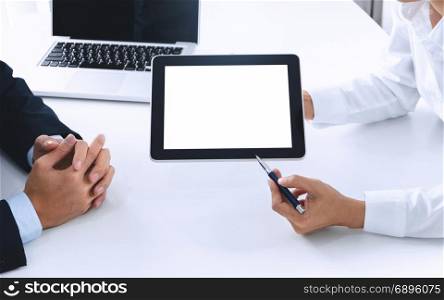 Business people working together and using blank screen digital tablet at a workplace